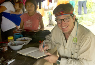 Dean  Jacobs sitting at a table writing in his journal