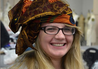 Fashion student wearing orange and brown headdress she designed