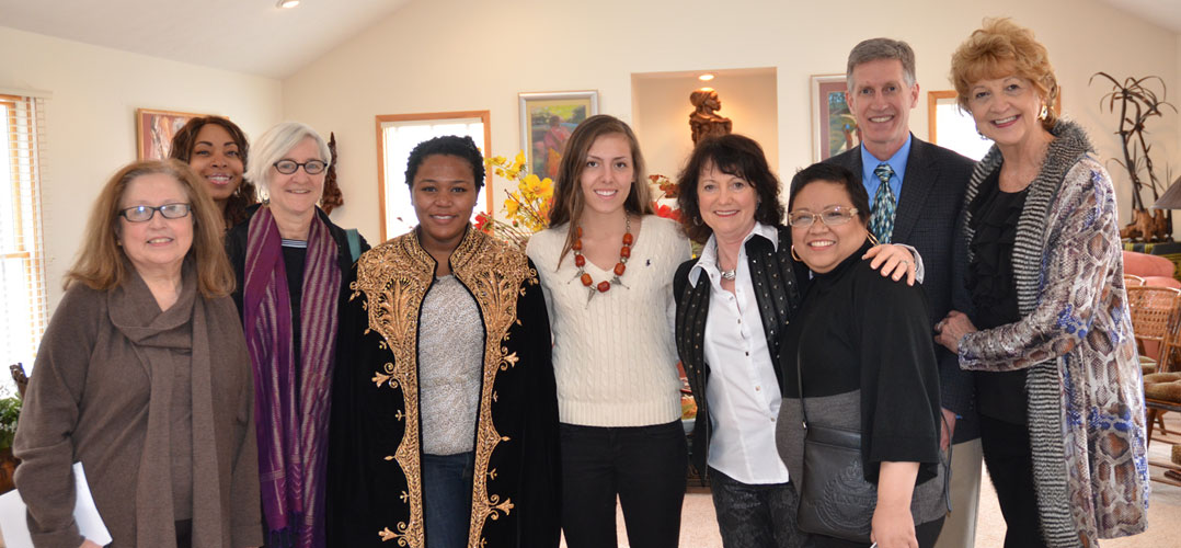Group of nine posing in front of African artworks