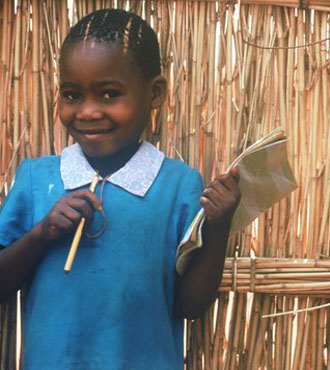 Young African girl in a blue dress with a big smile