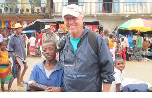 American teacher posing with African student in a market