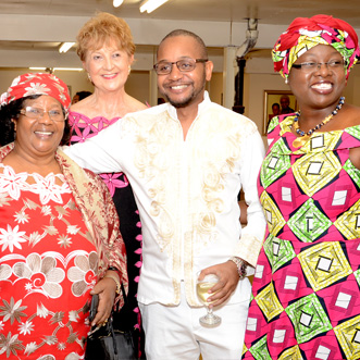 Group of three Africans and one American woman standing together smiling