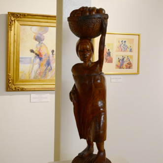 African wooden statue of woman carrying basket on top of her head