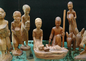 Group of carved statues of people around a nativity