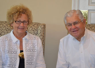 Senior man, who is an auctioneer, and women sitting side by side