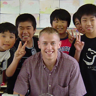 Young teacher posing with four young Asian children