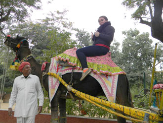 Student riding atop an elephant in Africa